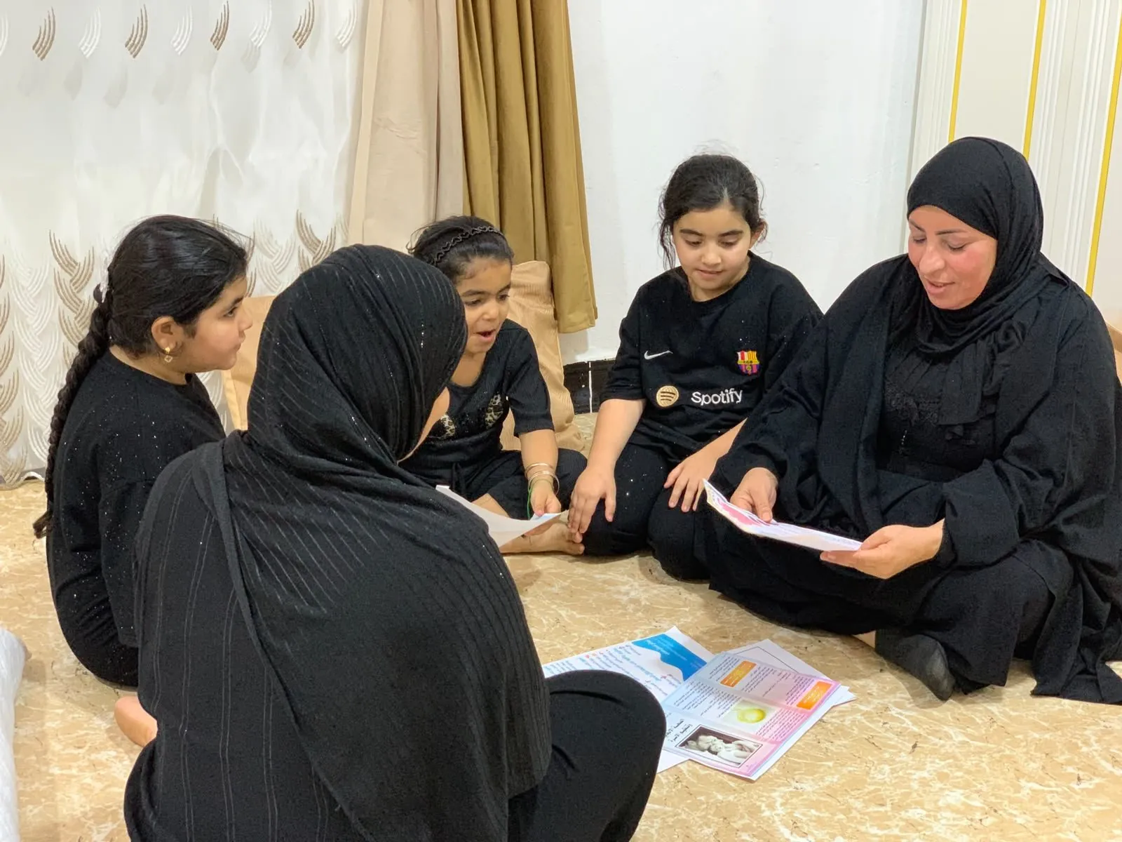 A volunteer talks with girls at home