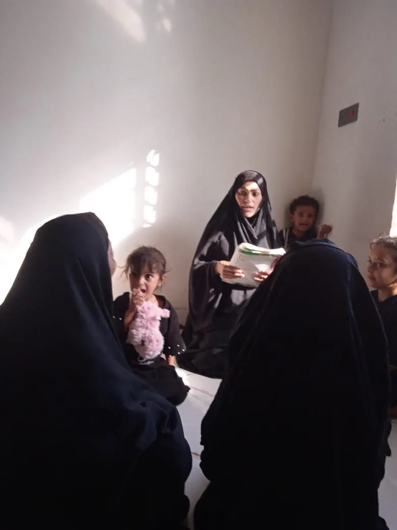 A volunteer with a mother and baby