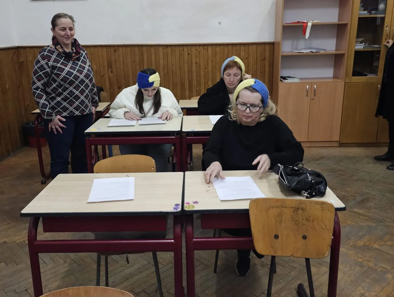 Ukrainian women in blue and yellow knitted headbands at an embroidery class, Sighetu Marmației